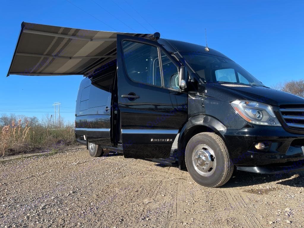 Black Airstream Class B campervan with awning deployed
