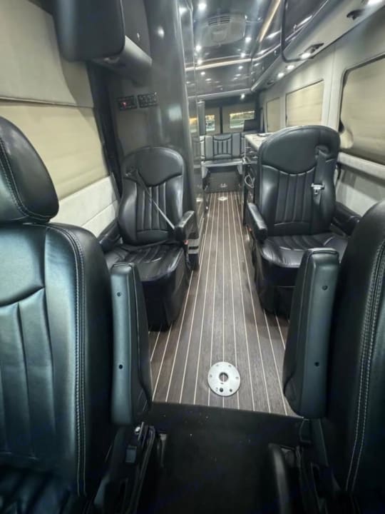 Class B campervan interior with aisle, seating, and rear sleeping area