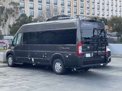Black Class B van parked near a hospital building
