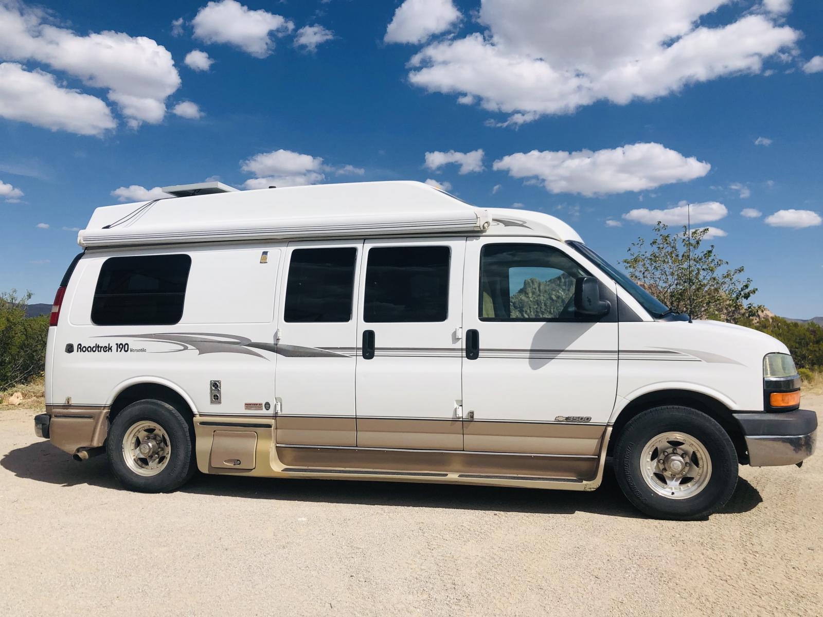 White Roadtrek 190 Class B RV parked under a blue sky