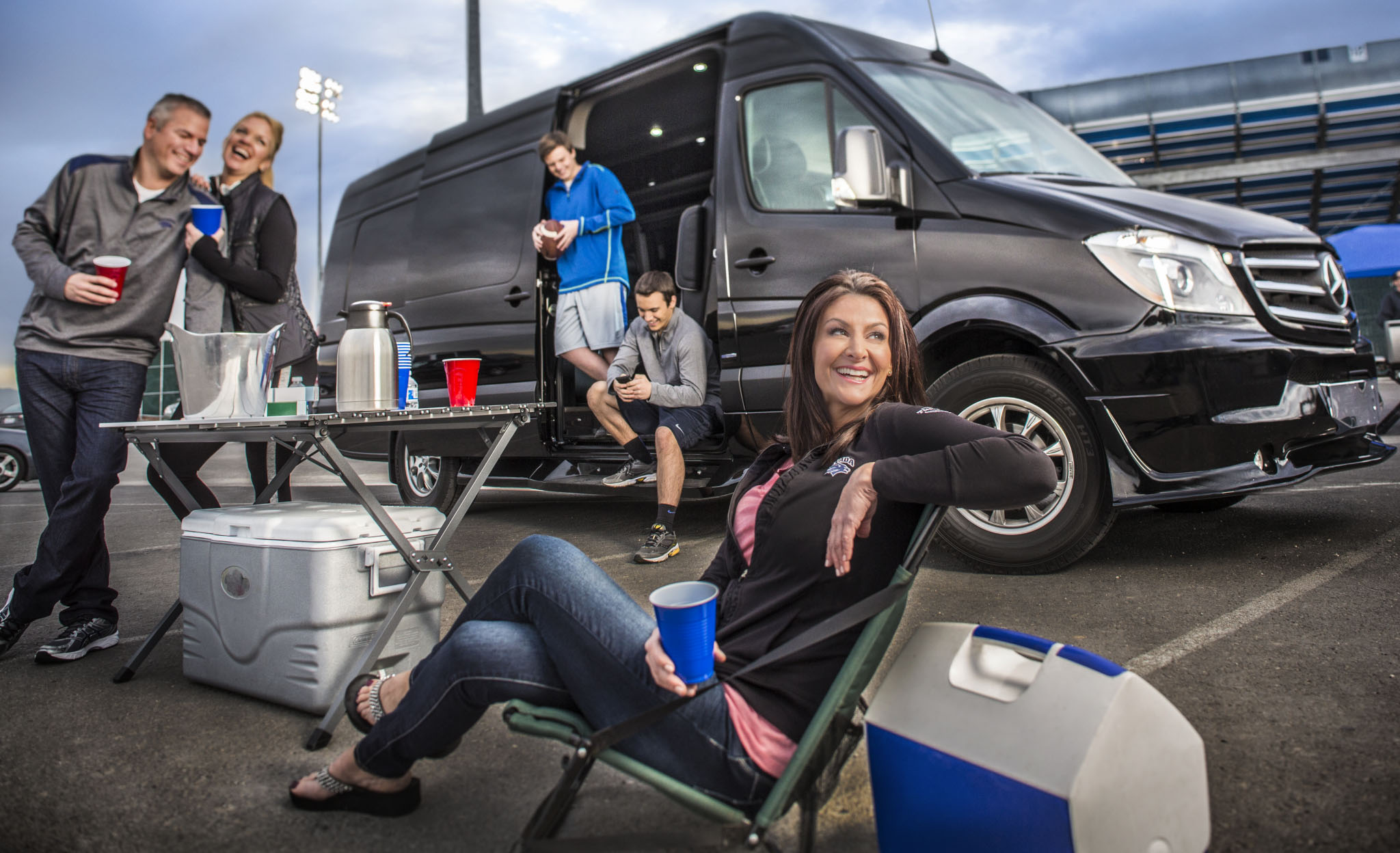 Tailgating group beside a black Mercedes van
